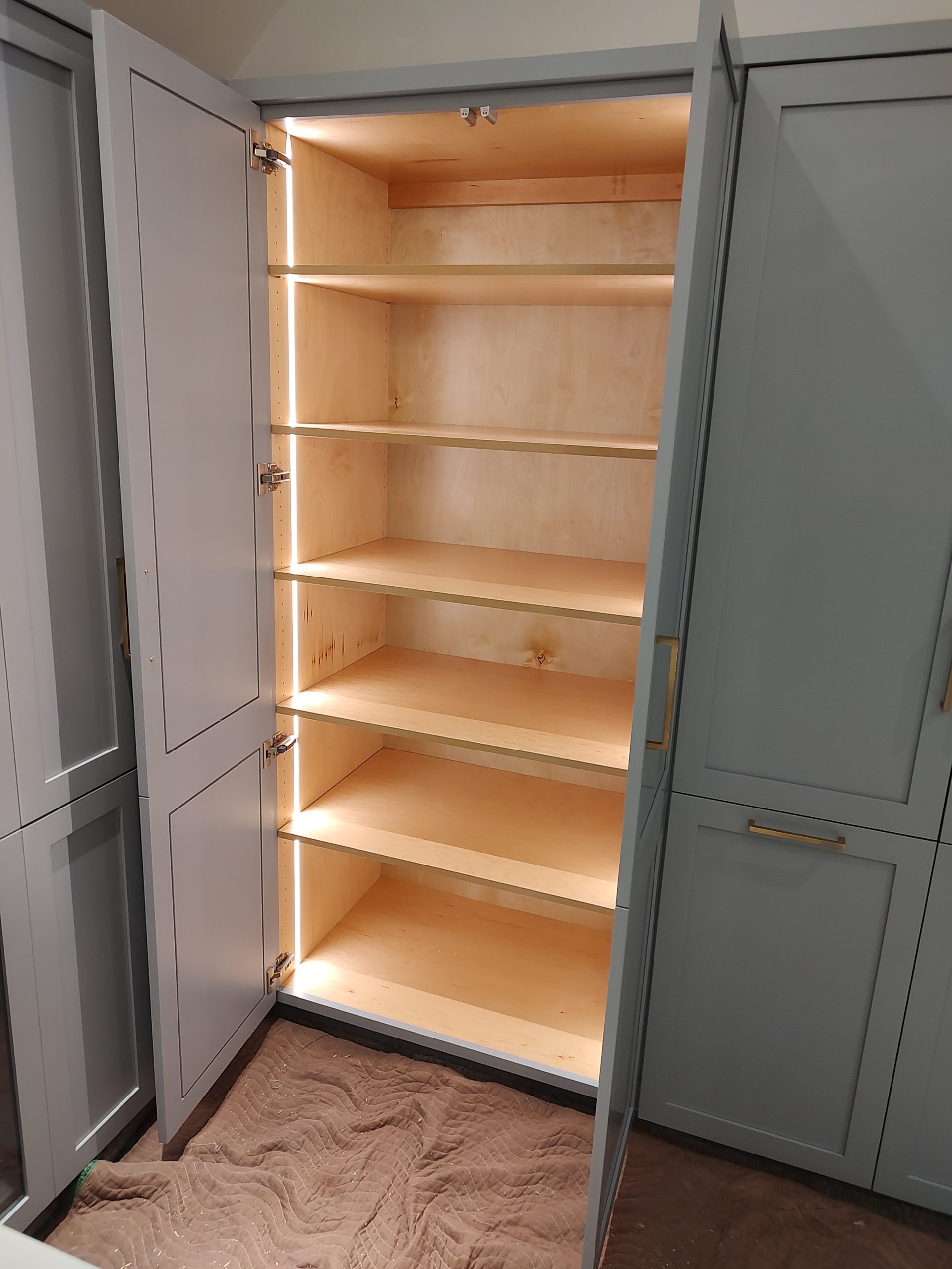 Custom luxury closet featuring blue-gray painted built-in cabinets