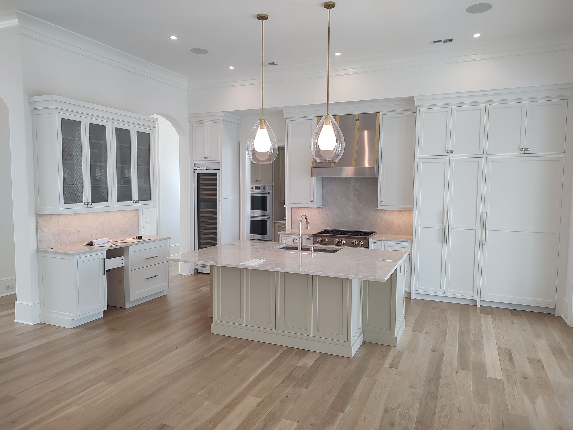 Custom build white cabinets with stainless steel range hood and sandstone counter